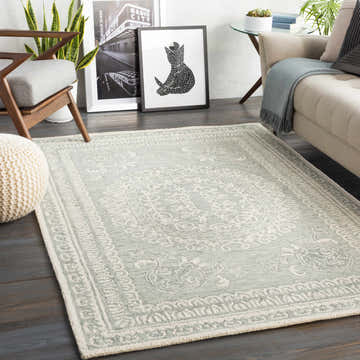 Living room scene with Parson Ivory/Sage Wool Area Rug, beige sofa, wood chair, and dark wood floors. Roomscene-Rectangle