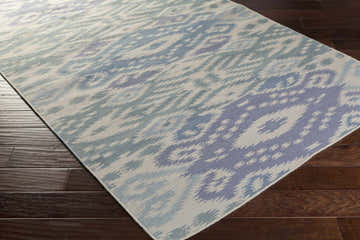 Close-up of the Prunedale Area Carpet in blue, denim, and gray on dark wood floors. Hand-woven wool rug. Corner