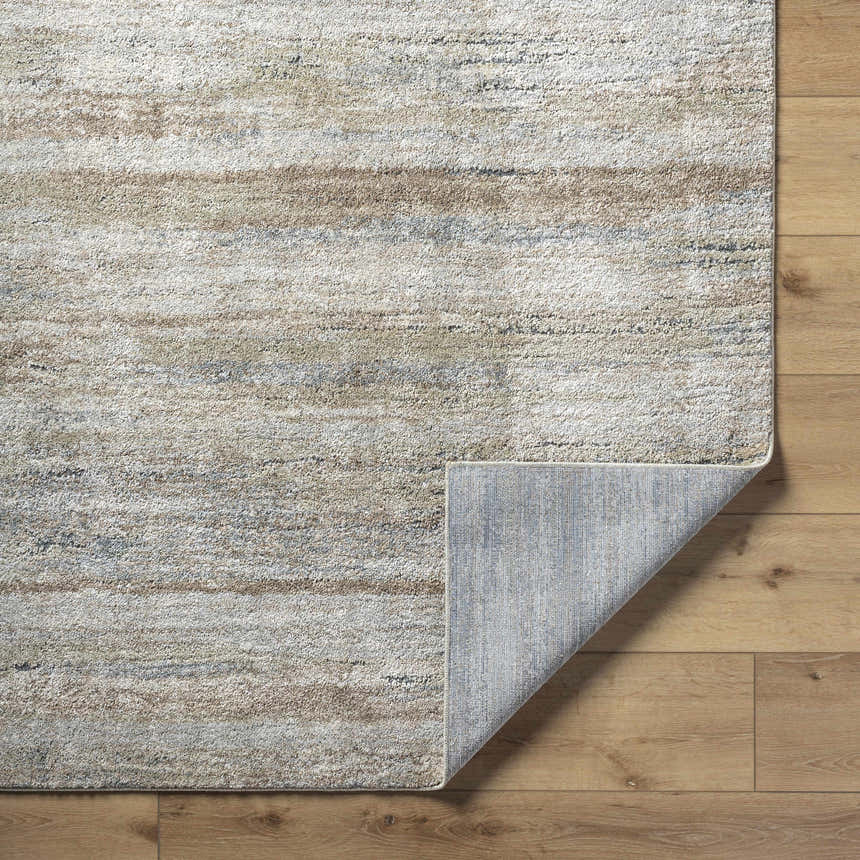 Close-up of the Agueda Thick Luxe Rug showing beige, light gray, olive, tan, and teal hues and the rug backing. Fold