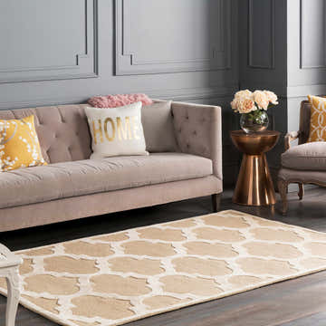 Living room scene with beige sofa, gold accents, and the Quicksand Area Rug in a neutral geometric pattern. Roomscene-Rectangle