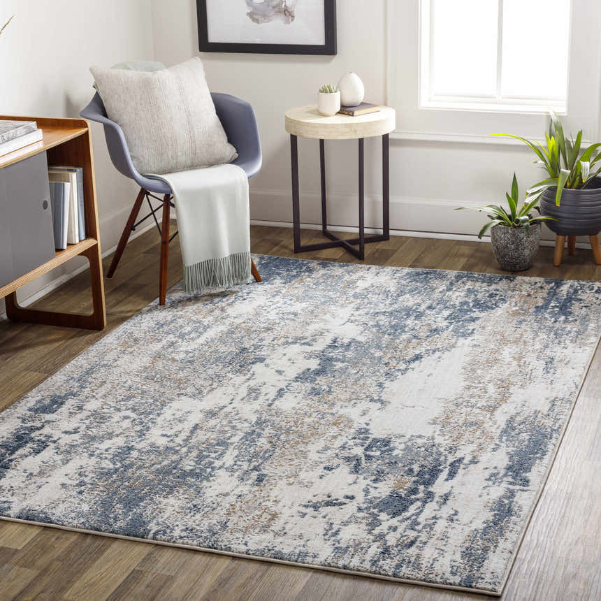 Living room scene with the Ord Area Rug in dark gray, denim, and ivory. Contemporary style with chair, table, and plants. Roomscene-Rectangle