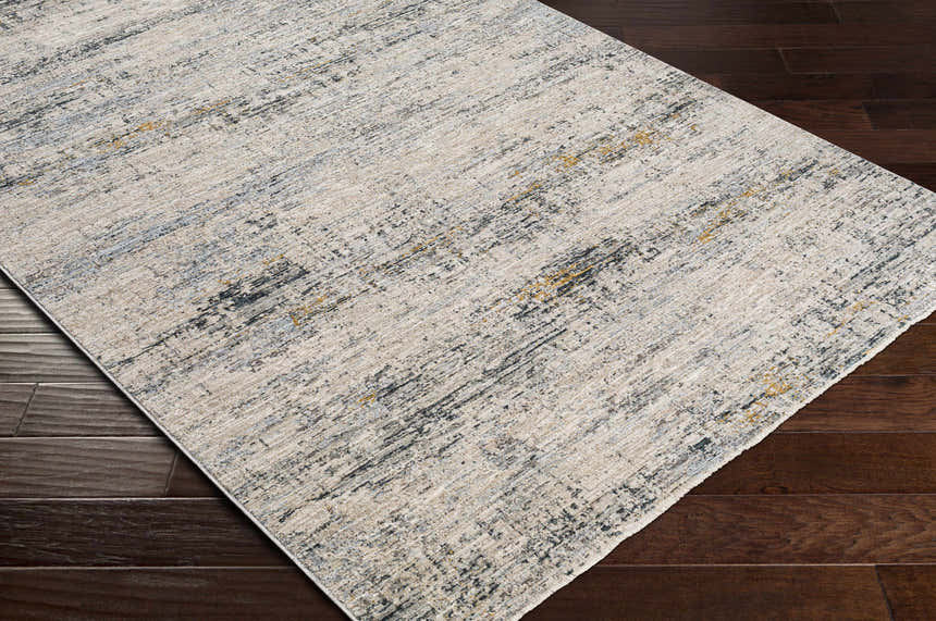 Close-up of the Rendlesham Luxe Rug. Contemporary design in cream, gray, and mustard tones on dark wood flooring. Corner