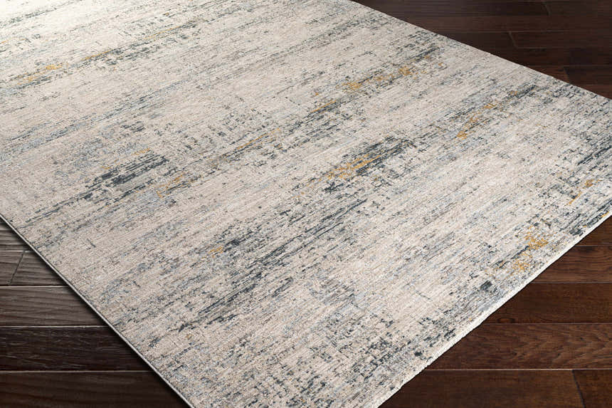 Close-up of the Rendlesham Luxe Rug showing its cream, gray, and mustard abstract design and soft texture on a dark wood floor. Corner