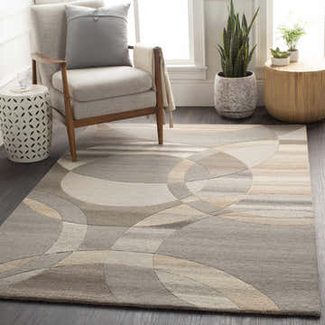 Living room scene with a Rillton Modern Wool Rug. The rug features a geometric circle pattern in beige, tan, and gray tones. Roomscene-Rectangle