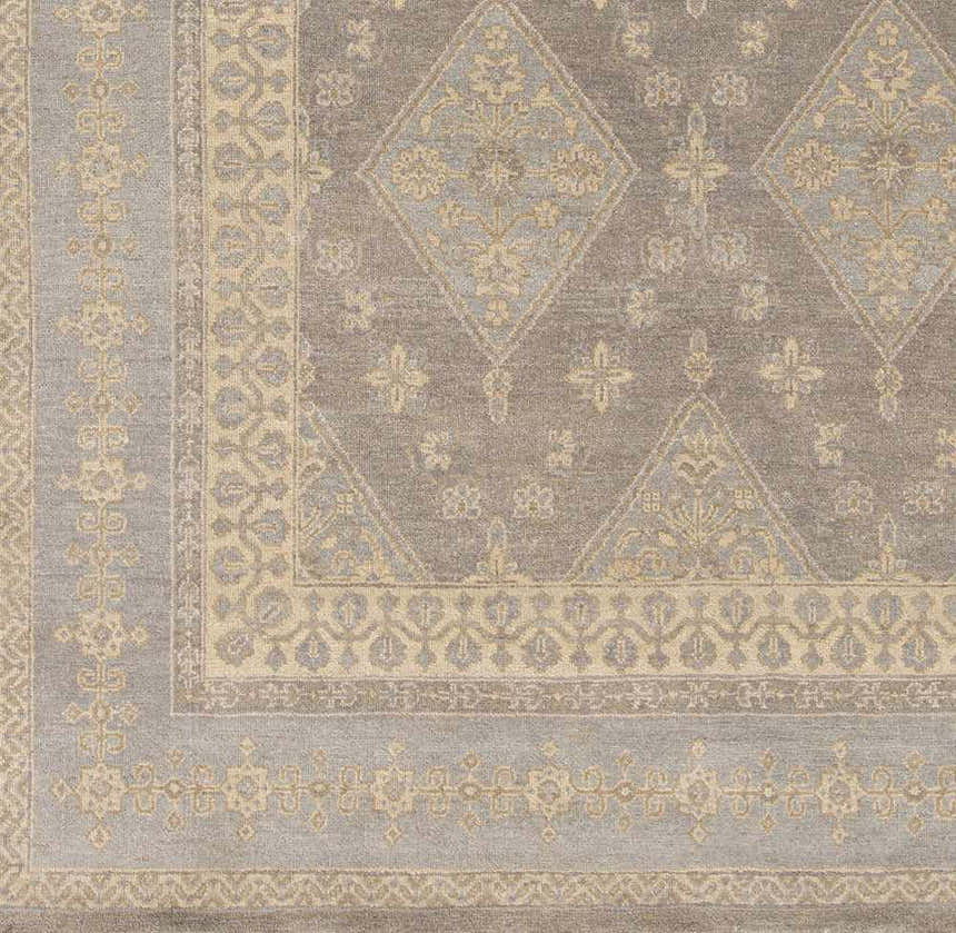 Close-up of the Roma Area Rug. Hand-knotted wool rug in medium gray and taupe with traditional diamond and floral pattern. Swatch