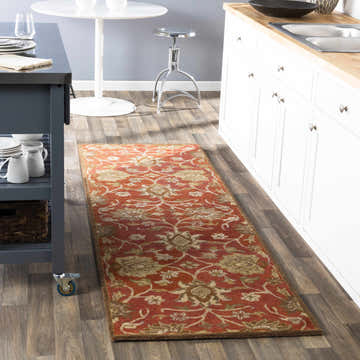 Rust Conesus Hand Tufted rug in a kitchen. The runner rug features a traditional floral pattern in brick red, burnt orange, and tan. Roomscene-Runner