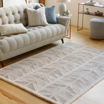 Living room scene with a beige sofa and the Rosewell Area Rug in beige and tan geometric pattern. Roomscene-Rectangle