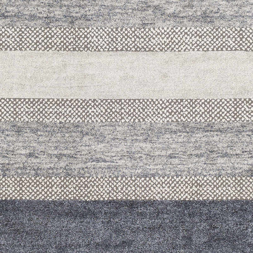 Close-up of the Ravendale Area Rug, featuring a cream, gray, and slate striped pattern with a textured, machine-woven construction. Swatch