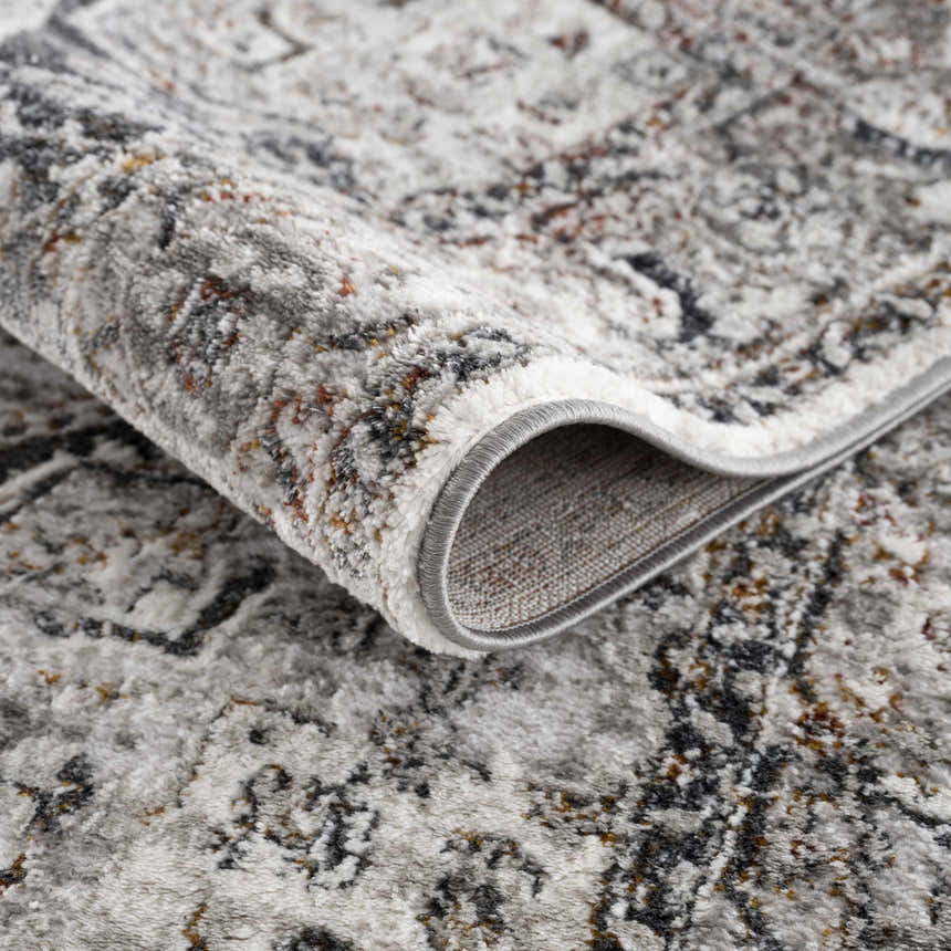 Close-up of the Liverpool Dark Gray Area Rug showing its textured, abstract design and charcoal, rust, and gray colors. Fold
