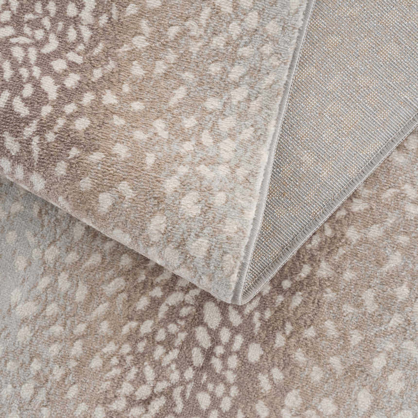 Close-up of the Pointblank Tan Leopard Print Rug showing the animal print pattern, texture, and backing. Fold