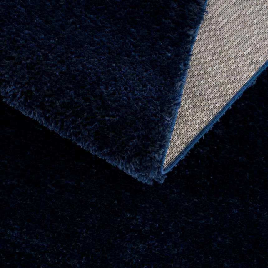 Close-up of the Navero Dark Blue rug showing its plush texture, subtle wavy pattern, and durable backing. Fold