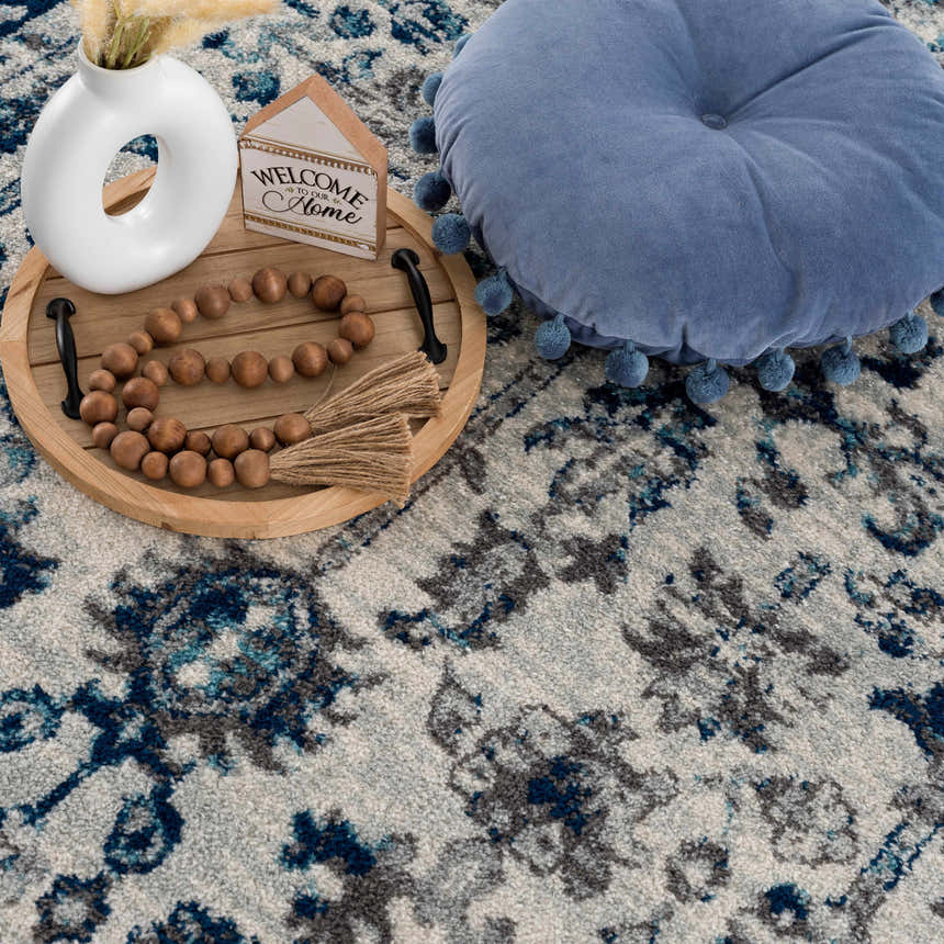 Close-up of the Istanbul Vintage Blue Area Rug showing its ivory, navy, and gray vintage-style pattern. Styleshot