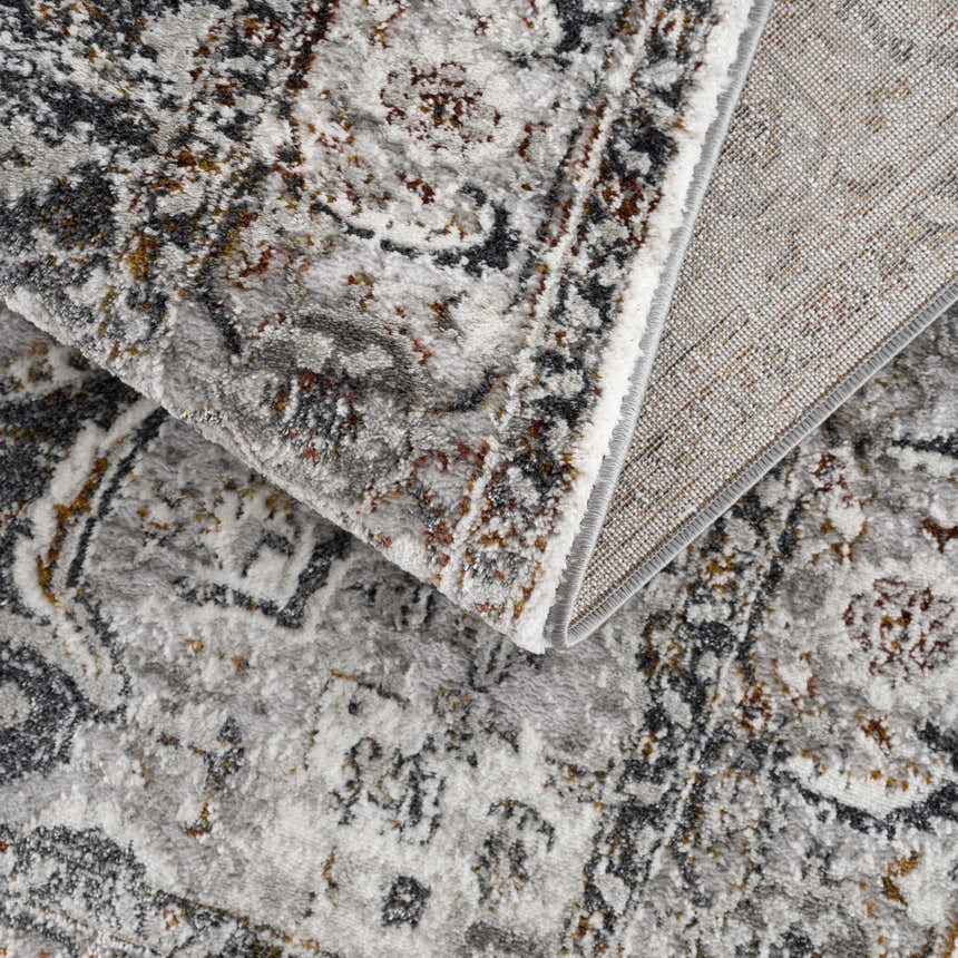 Close-up of the Liverpool Dark Gray Area Rug showing its charcoal, gray, rust, and off-white traditional design. Fold