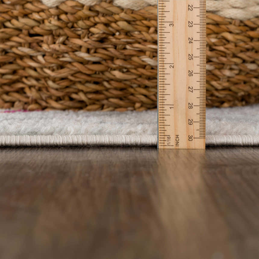 Close-up of the Istanbul Aztec Area Rug showing the pile height with a ruler and a woven basket. Pile