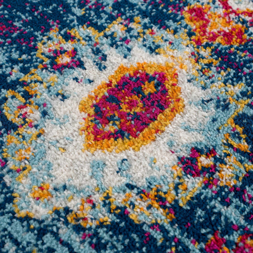 Close-up of the Istanbul Medallion Blue & Orange Area Rug showing its navy, turquoise, orange, and pink bohemian pattern. Texture