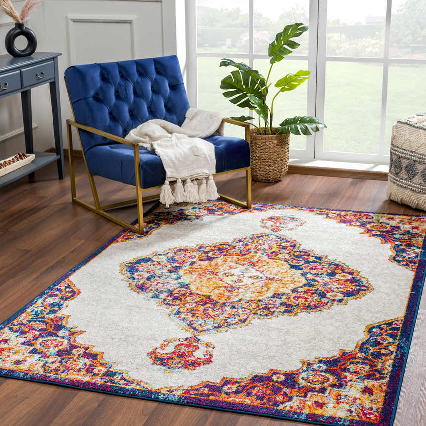 Living room scene with a blue velvet chair and the Istanbul Orange Area Rug, a colorful bohemian accent. Roomscene-Rectangle