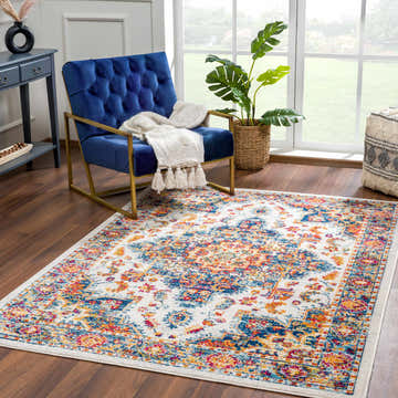 Living room scene with Istanbullu Blue & Orange Area Rug, blue velvet chair, wood floors, and bright natural light. Roomscene-Rectangle