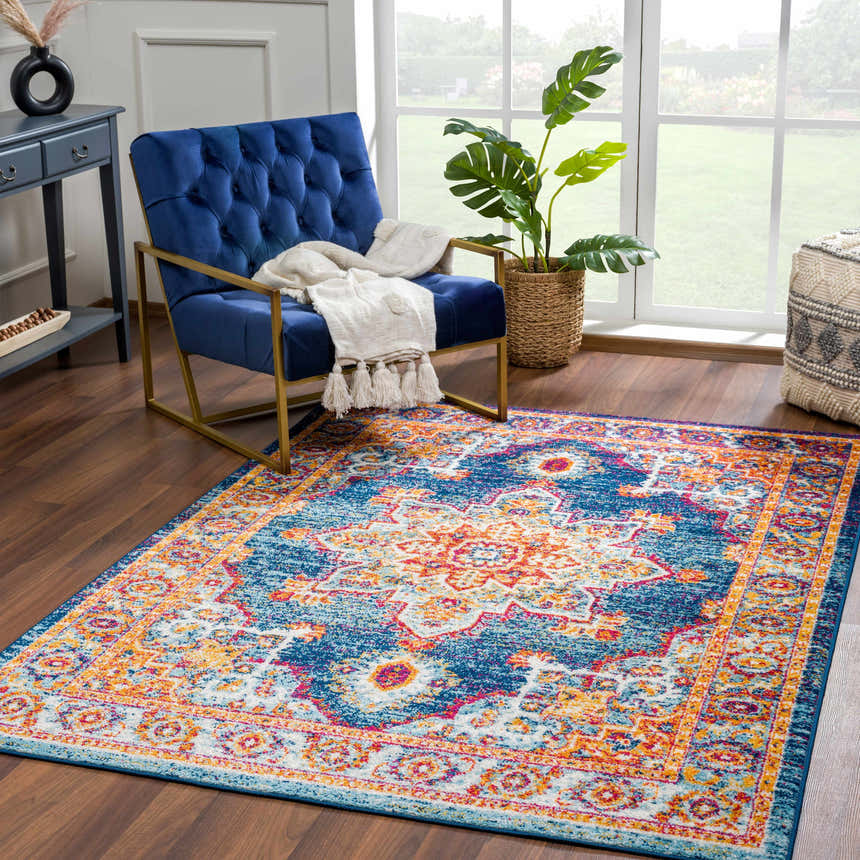Living room scene with Istanbul Medallion Blue & Orange Area Rug, blue velvet chair, and natural light. Roomscene-Rectangle