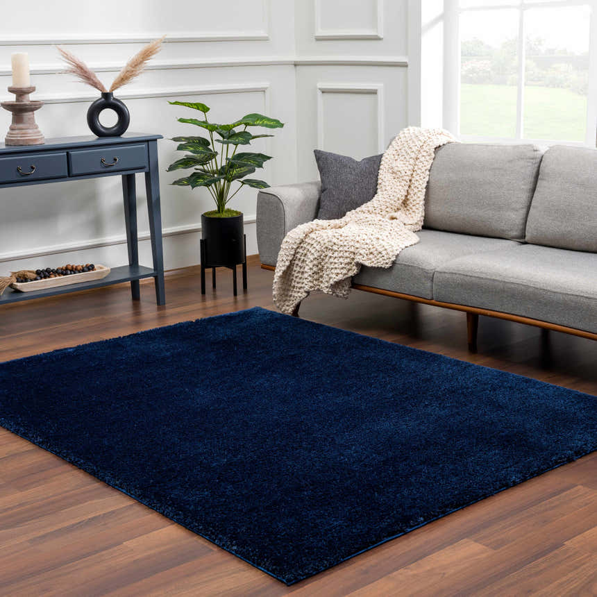 Living room scene with gray sofa and Navero Dark Blue abstract rug on wood floor. Minimalist style. Roomscene-Rectangle