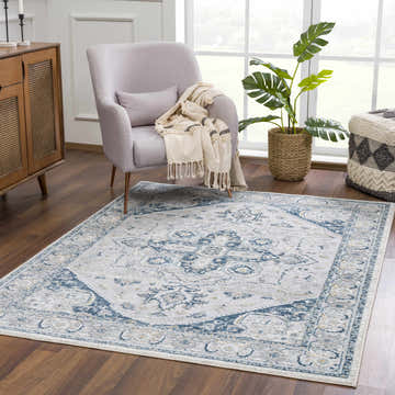 Living room scene with the Liverpool Blue Area Rug, light gray armchair, wood cabinet, and monstera plant. Roomscene-Rectangle