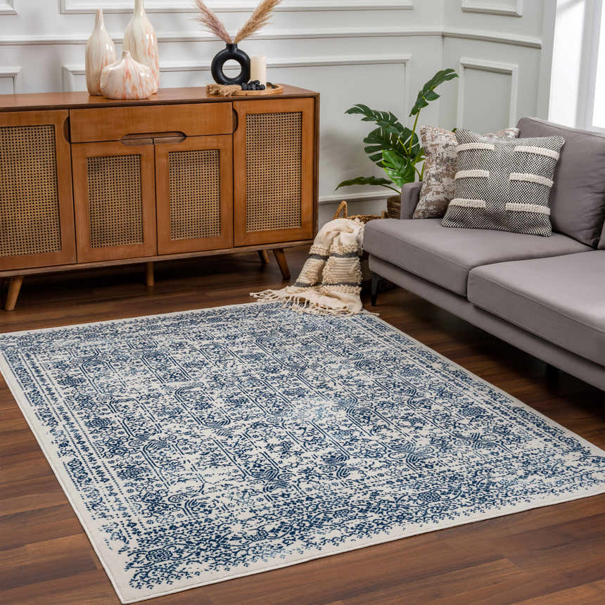 Living room scene with a Michie Blue Area Rug, gray sofa, wood cabinet, and boho decor. Roomscene-Rectangle