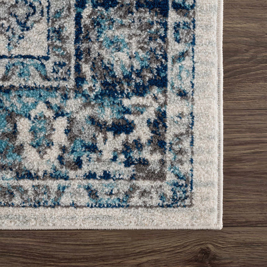 Close-up of the Istanbul Vintage Blue Area Rug showing its ivory, navy, and gray vintage pattern and soft texture. Swatch