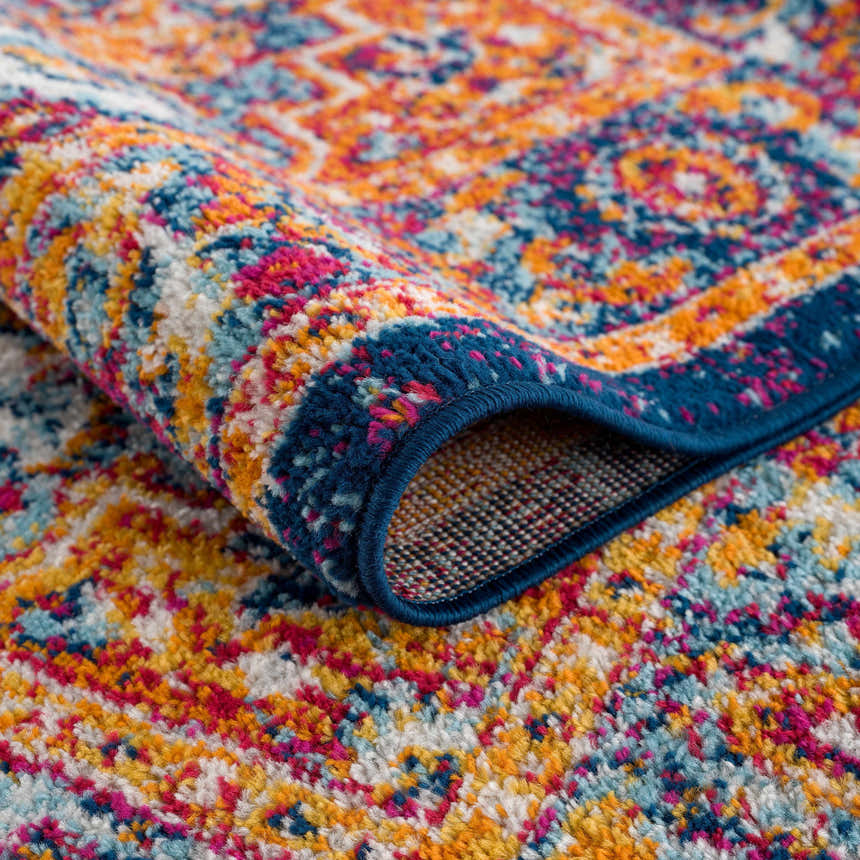 Close-up of the Istanbul Medallion Blue & Orange Area Rug showing its traditional pattern, navy border, and textured polypropylene. Fold