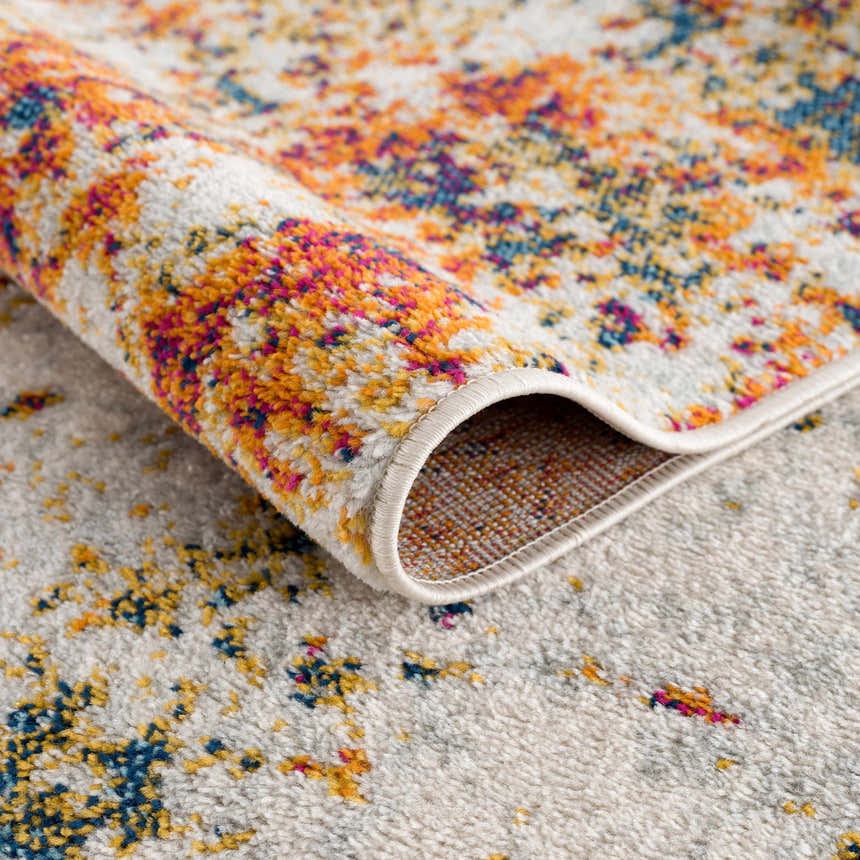 Close-up of the Istanbul Abstract Area Rug showing the ivory, blue, mustard, and pink abstract design and soft texture. Fold