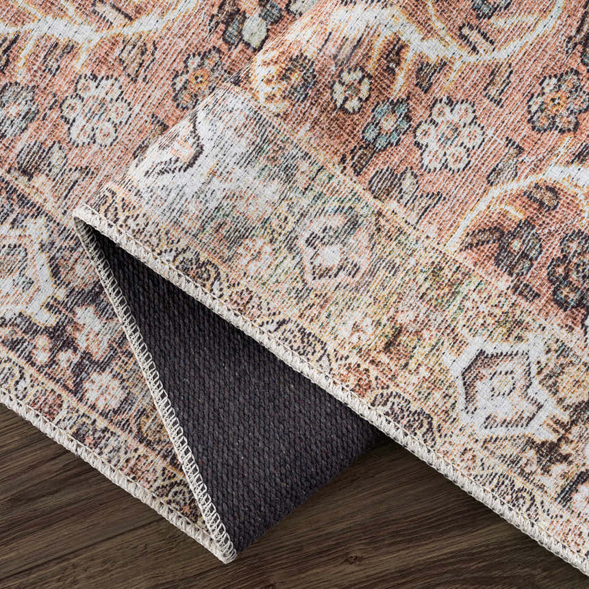 Close-up of the Bian Washable Area Rug showing its Persian-style design, brown, beige, and aqua colors, and durable backing. Fold