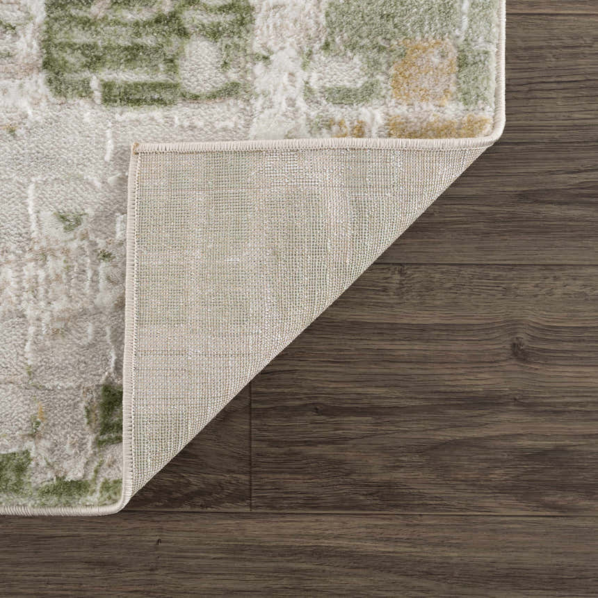Close-up of the Liveri Green Mosaic Rug showing its abstract pattern, colors, texture, and backing. Fold