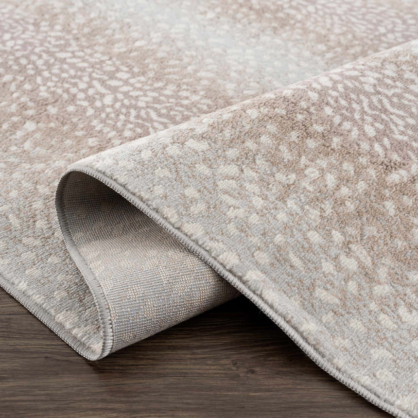 Close up of the Pointblank Tan Leopard Print Rug showing its texture and backing. Fold