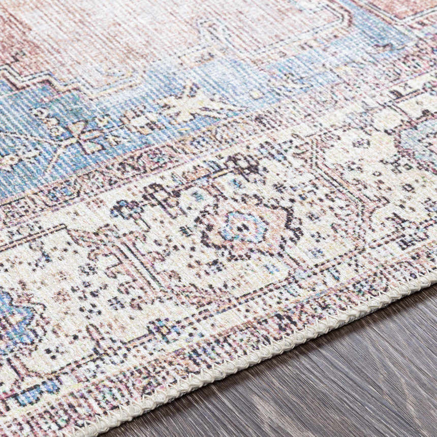 Close-up of the Sacriston Washable Area Rug showing its aqua, blue, and rose bohemian pattern and soft texture. Texture