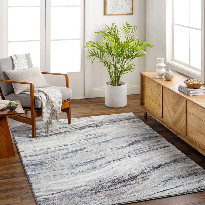 Living room scene with a Glain Gray & Blue Marble Area Rug, gray chair, wood console, and plant. Modern, neutral tones. Roomscene-Rectangle