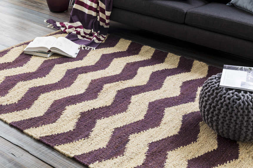 Living room scene with beige and dark purple Saginaw Jute Carpet featuring a bold zigzag pattern. Styleshot