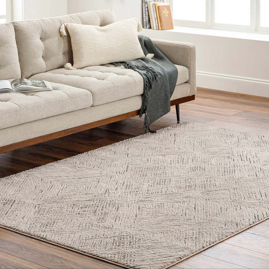Living room scene with a beige sofa and a Garza Diamond Textured Washable Rug in beige and gray on a wood floor. Roomscene-Rectangle