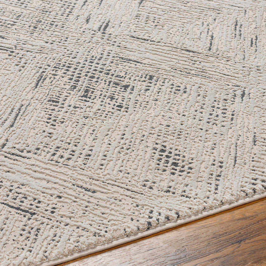 Close-up of the Garza Diamond Textured Washable Rug. Beige and gray rug features a subtle diamond pattern and textured weave. Texture