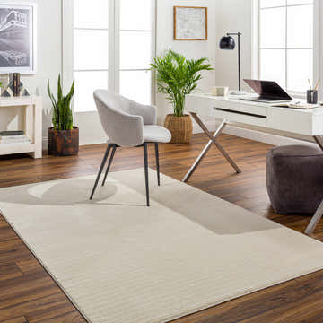 Bright home office with a Lambswool Kini Plush Textured Washable Rug, desk, gray chair, and plants. Roomscene-Rectangle
