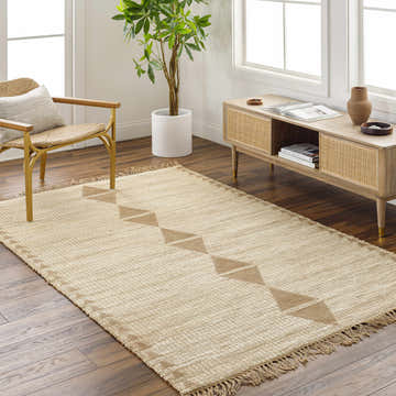 Living room scene with a Marie Jute Rug in ash and khaki, woven texture, geometric pattern, with chair and console table. Roomscene-Rectangle