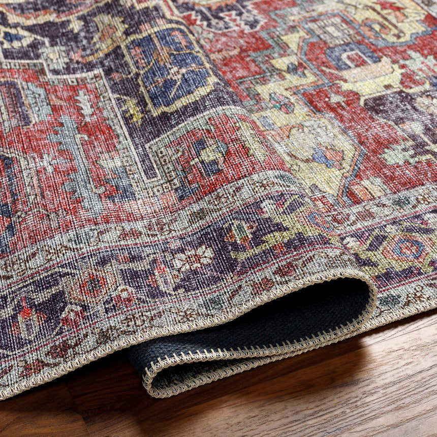 Close-up of the Reza Red Washable Rug showing its traditional, multi-brown, garnet, and bone colored pattern and woven texture. Fold