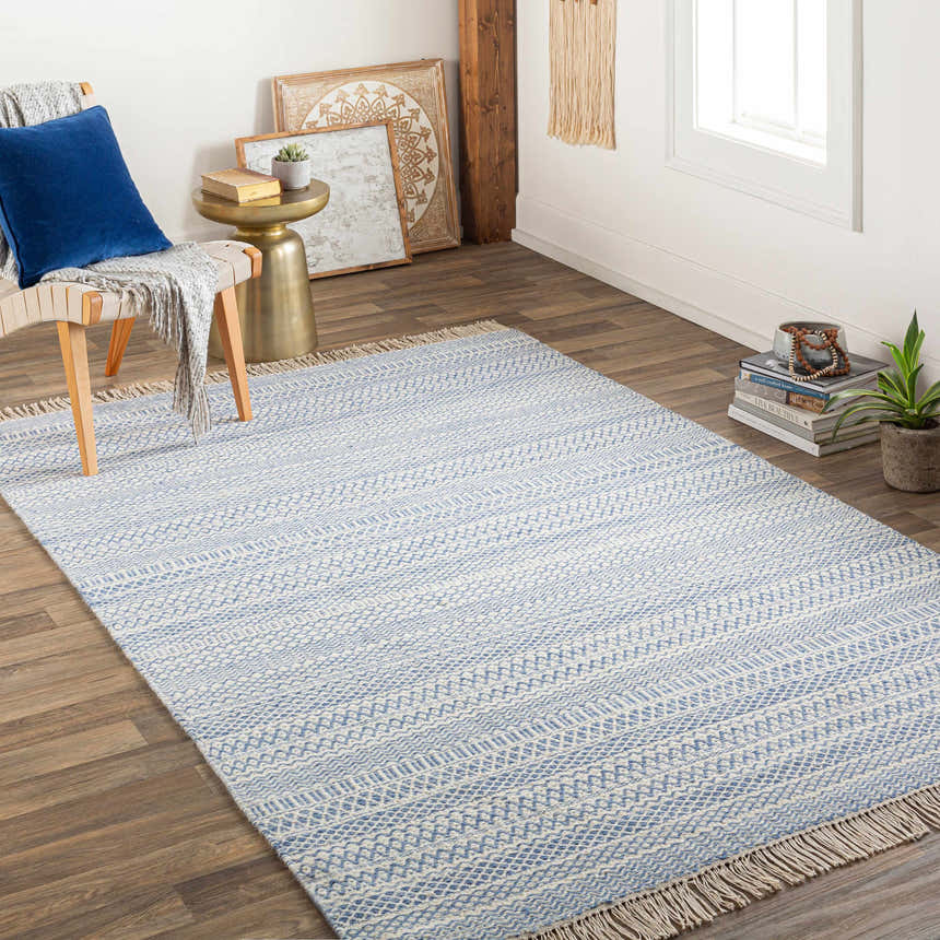 Light-filled living room with blue and cream Sanc Flatweave Wool Rug, wood floors, and neutral decor. Roomscene-Rectangle