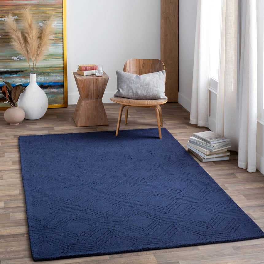 Living room scene with dark blue Sarona Area Rug, wood chair, and modern decor. Roomscene-Rectangle