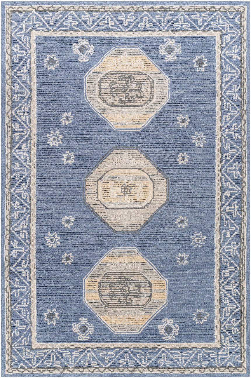 Close-up of the hand-tufted Arwan Area Rug. Farmhouse style with blue, beige, and gray geometric patterns and floral accents. Design-Rectangle-576