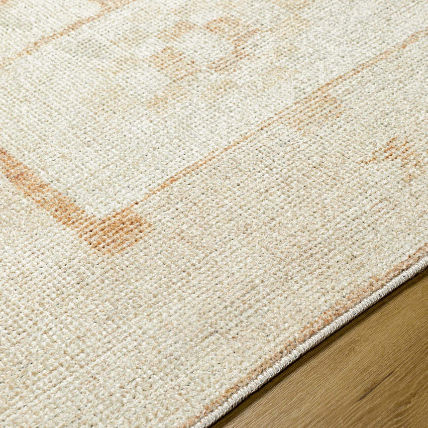 Close-up of the Solana Medallion Peach rug. Beige rug with a subtle peach medallion pattern and soft, woven texture. Texture