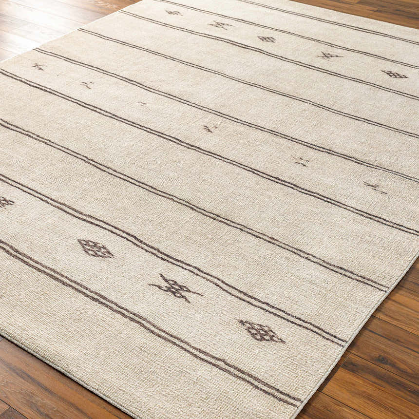 Close-up of Rivi Moroccan Beige rug. Farmhouse style rug with beige, bone, and dark brown stripes and geometric design. Corner