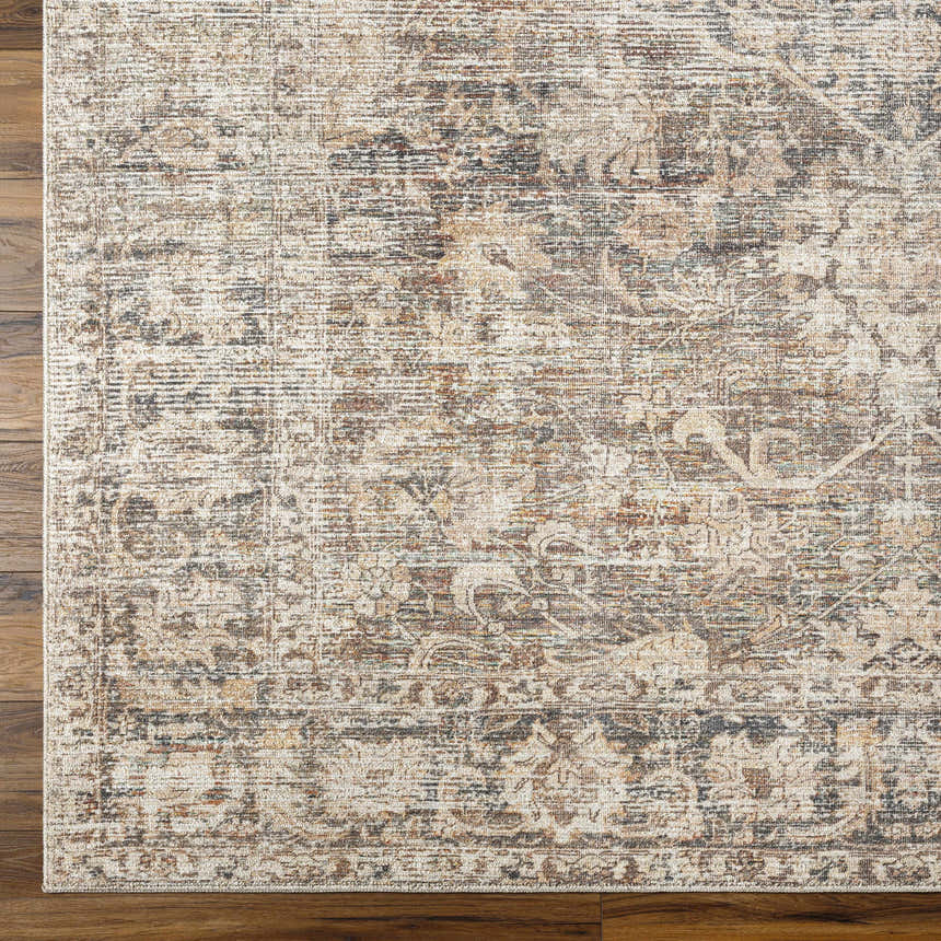Close-up of the Marlene Medallion Brown Area Rug. Beige, brown, and black farmhouse-style rug with a traditional medallion pattern. Corner