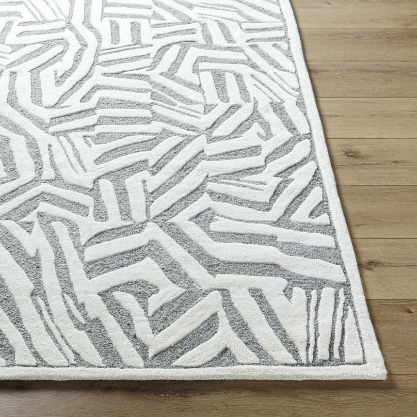 Close up of the Avian Gray Wool Area Rug showing its cream abstract pattern and hand tufted texture. Front