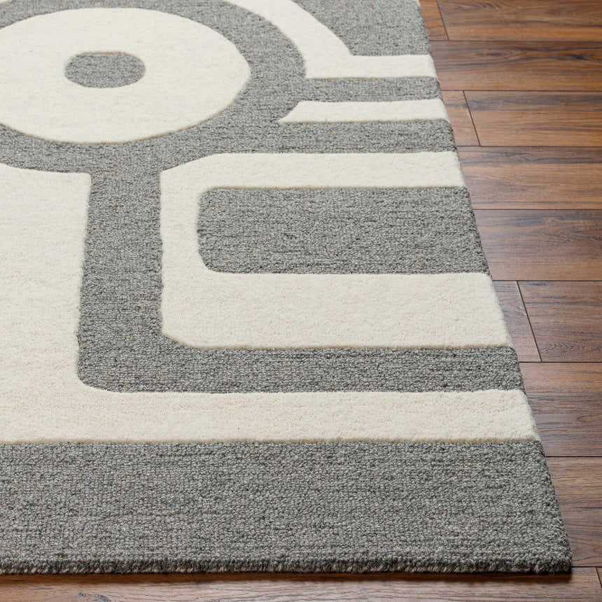 Close-up of the Daryl Area Rug showing a gray and ivory geometric design and hand-tufted wool texture. Front