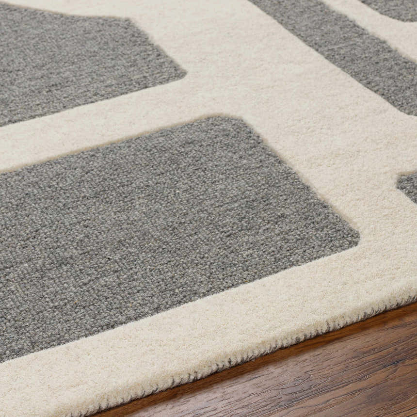 Close up of the Daryl Area Rug showing its gray and ivory geometric pattern and wool texture. Texture