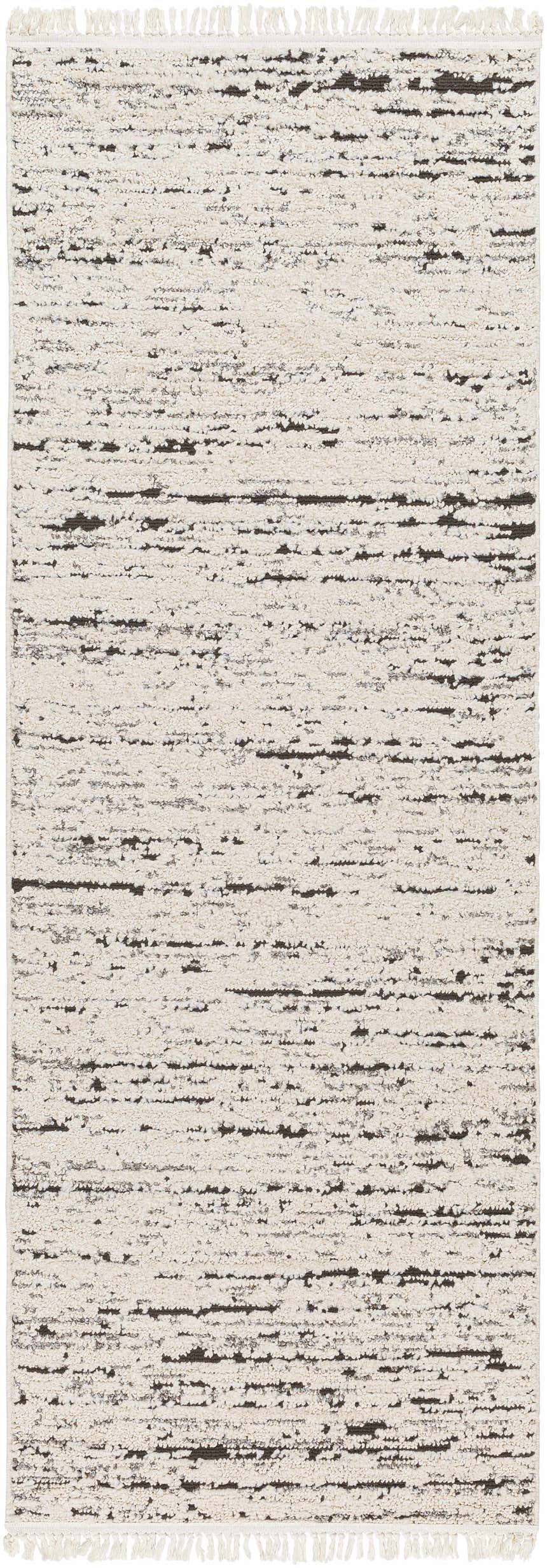 Close-up of Elian Area Rug in bone and dark brown. Bohemian style with a soft, textured pile and fringe. Design-Runner-2773