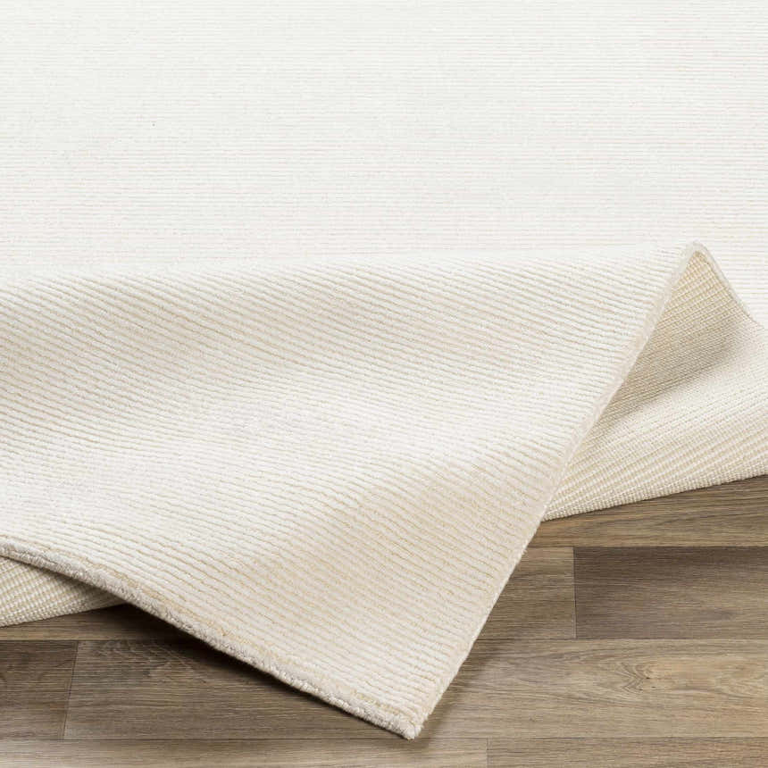 Close-up of the hand-knotted Sabinsville Carpet, showing its textured, cream viscose pile and subtle striped design. Fold